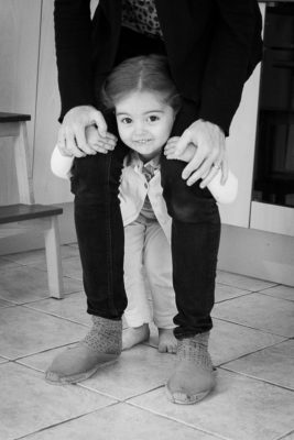 fillette accrochées aux jambes de sa maman