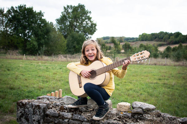 Enfant et sa guitare dans son jardin