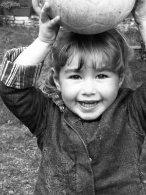 Petite Fille qui tient un ballon sur sa tête