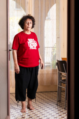 Portrait de Rita, avec son tshirt rouge dans sa cuisine